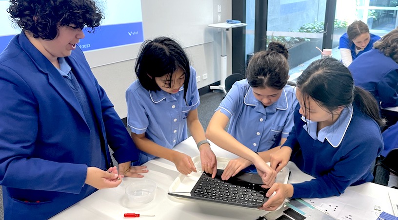 Students taking apart a laptop computer